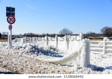 Fence covered with an ice crust after a winter storm on the Baltic sea coast