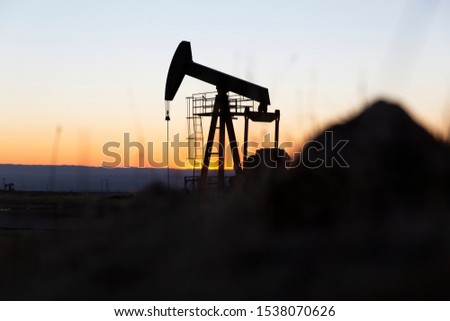 View of Oil Well Pumpjack (Horsehead) at Sunset Oil Industry