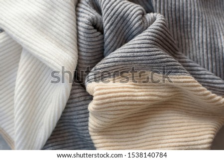 Warm knitted woolen takan pastel shades background, as a symbol of winter or Christmas.