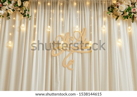 Luxury wedding decorations with hanging garland of light bulbs, flowers and letter A & A at evening wedding ceremony, copy space