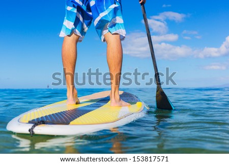 Young Attractive Mann on Stand Up Paddle Board, SUP, in the Blue Waters off Hawaii Royalty-Free Stock Photo #153817571