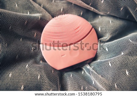 top view of pink silicone cleansing facial brush. Facial cleansing device