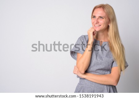 Portrait of happy young beautiful blonde woman thinking