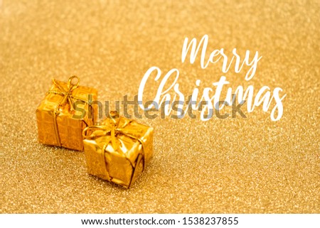 Merry Christmas Sign on a golden backgroud images. Golden Christmas background stock images. Golden holiday background with presents. Christmas gift boxes. Golden decorations on shiny background