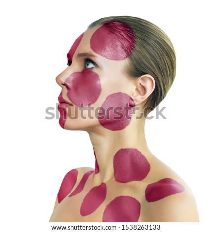 Portrait of a young woman with creative makeup posing in the studio. Painted circles on woman face. Isolated on white background.