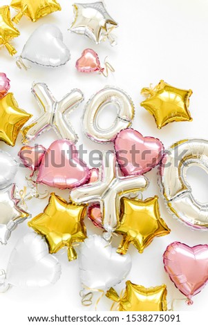 XO foil balloon letters and air balloons of heart shaped and stars. Love concept. Holiday and celebration. Valentine's Day or wedding/bachelorette party decoration. Colorful Metallic  air balloons. 