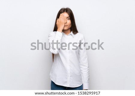 Young woman over isolated white background covering a eye by hand