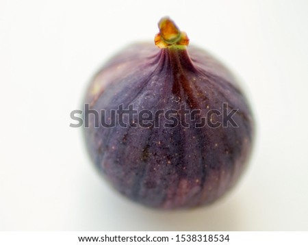 Ripe sweet fig on white blurred table. Selective focus.