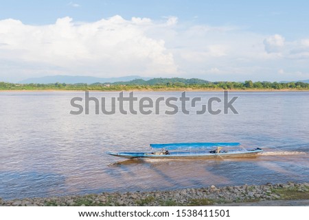 Boat on the Mekong River Traveling between Thailand and Laos in Chiang Saen,  Landmark of Chiang Rai. Located in Thailand. Picture for Chiang Rai Travel Concept.