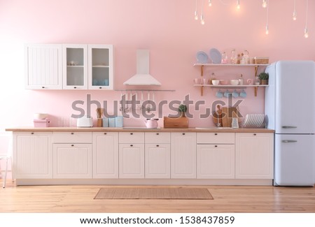 Stylish pink kitchen interior with modern furniture and fridge Royalty-Free Stock Photo #1538437859