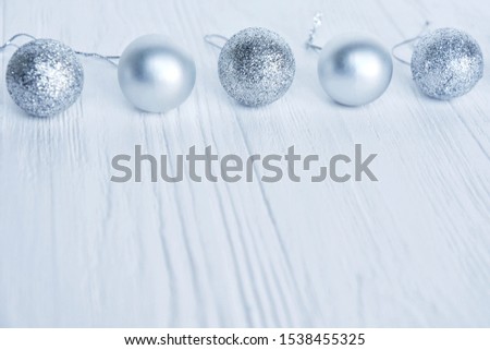 Row of Shiny Christmas balls with selective focus on a white wooden background. Christmas and New Year flat lay. New Year 2020 flat lay with silver decorative ball on white textured background. Soft 