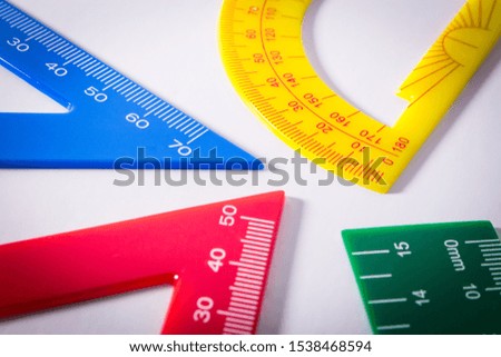Concept image of colourful rulers and protractor in white background.