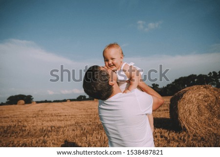 father and daughter joy game toss up baby on golden field background