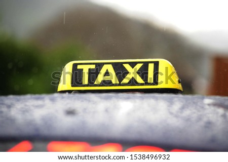 Taxi sign on the roof of the car