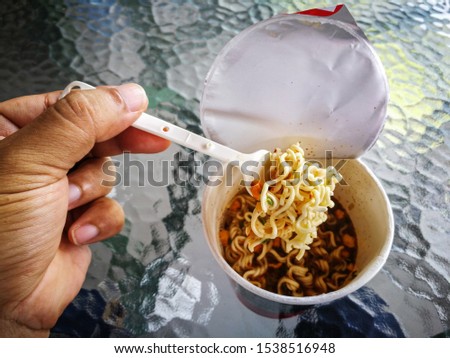 Hot and Spicy Instant cup noodles with shrimp  on 
glass table