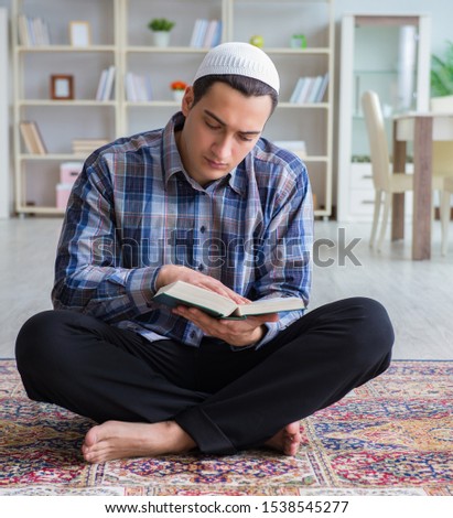 Young muslim man praying at home