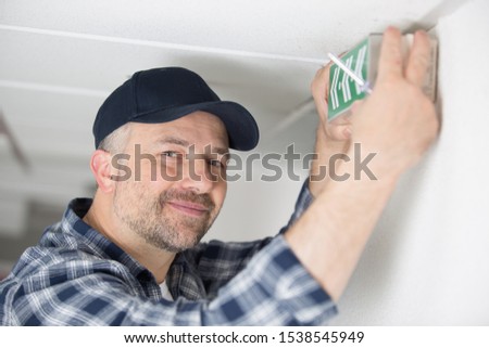 a male worker and emergency exit sign