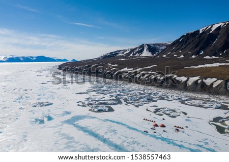 Aerial drone photo of tourists camping on the floe edge near Sirmilik National Park in Nunavut, Canada