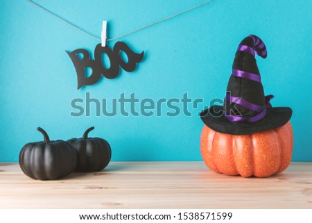Holiday concept with Halloween pumpkin decor and witch hat on wooden table. Creative Halloween minimal concept.