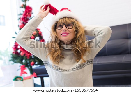adult woman at home smiling with santa claus hat