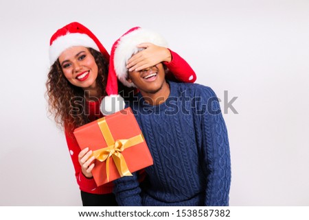 Studio portrait of young couple, boyfriend & girlfriend with dark skin wearing santa claus hat and christmas outfit. Ugly sweater concept. Close up, copy space for text, isolated background.