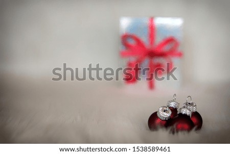 Christmas image, with red balls and in the background a gift box with blur
