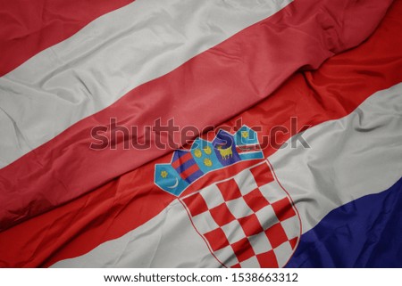 waving colorful flag of croatia and national flag of austria. macro