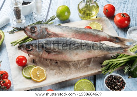 photo seafood and fish on parchment with vegetables on the Board