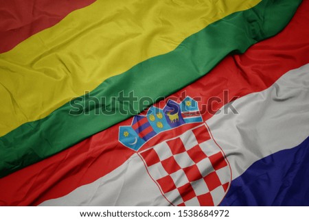 waving colorful flag of croatia and national flag of bolivia. macro