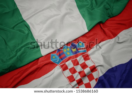 waving colorful flag of croatia and national flag of nigeria. macro