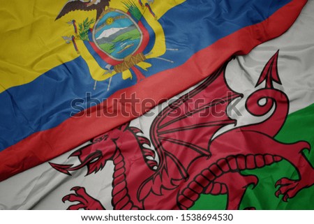 waving colorful flag of wales and national flag of ecuador. macro