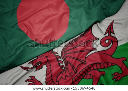 waving colorful flag of wales and national flag of bangladesh. macro