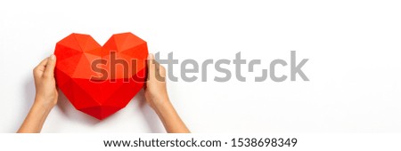 Hands holding red polygonal paper heart shape over white background