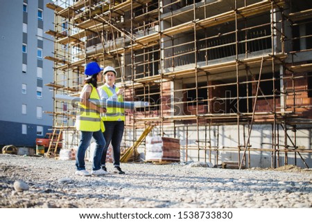 A two women construction workers on building site.Stock photo