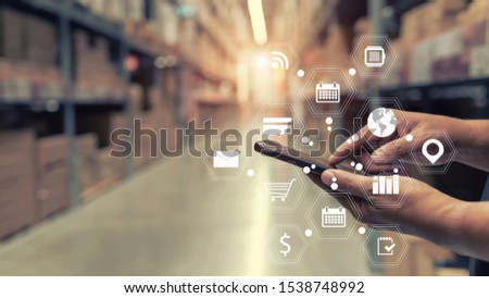 Shopping icons on a smartphone with Warehouse background, Logistics concept.