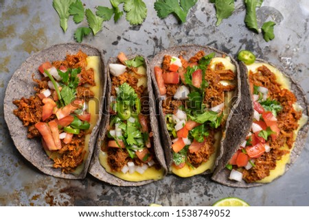 Traditional mexican quesadillas with shredded pork also called "chilorio" on rustic background