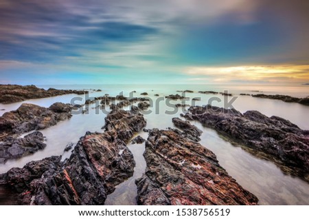 rocky beach with wonderful sunset , located at Terengganu, Malaysia
soft and grain effect. long exposure photography.
