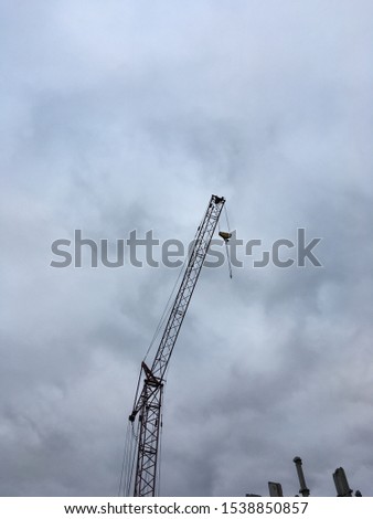 Construction crane on a background of gray sky.