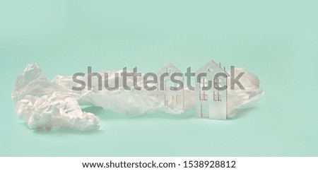mini houses and crumpled paper on green background. Business property, real estate, environment and ecology ideas. copy space