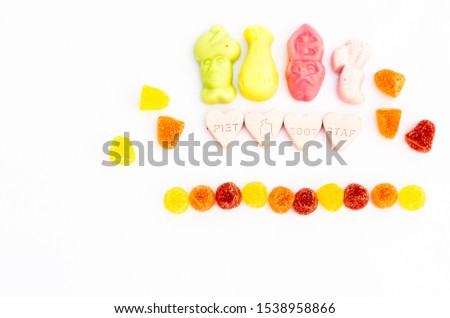 Hearts with text Piet, boat and staff. Surrounded by colored candies and meringues with space for text on a white background. Top view.