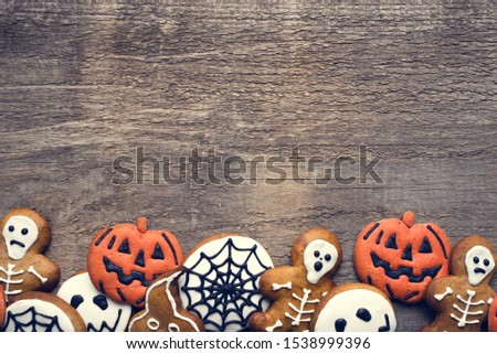 Halloween gingerbread cookies on wooden background. Flat lay. Copy space for your text.