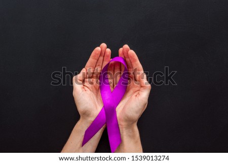 Lilac ribbon in hands is symbol of Alzheimers disease on white background top view copy space