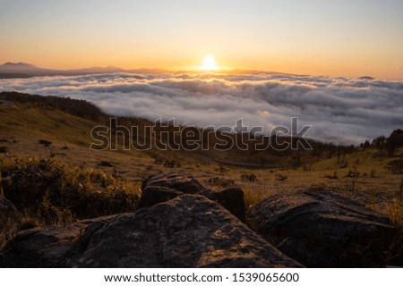 An early morning landscape consisting of the morning sun and sea of ​​clouds. The ground illuminated by the weak sunlight in the morning. Bihoro Pass, Hokkaido, Japan.