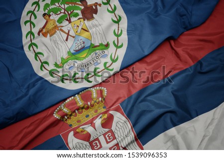 waving colorful flag of serbia and national flag of belize. macro