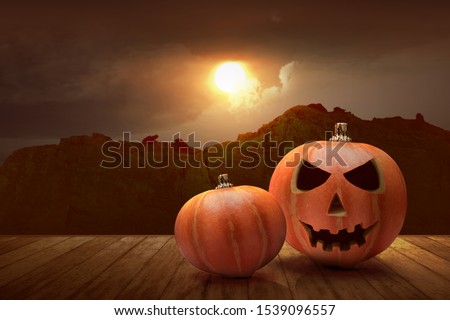 Jack-o-Lantern on the wooden table with a sunset sky background