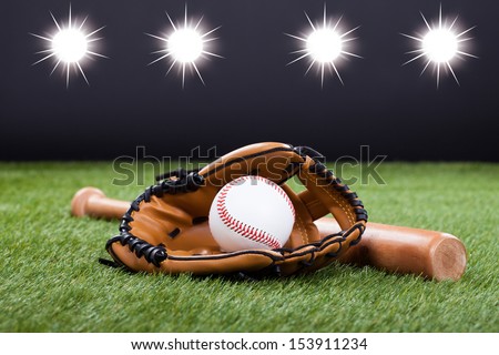 Baseball Glove With Baseball And Bat Lying On Green Grass