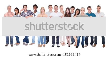 Group of stylish professional business people standing in a line holding up a long blank banner for your advertising or text