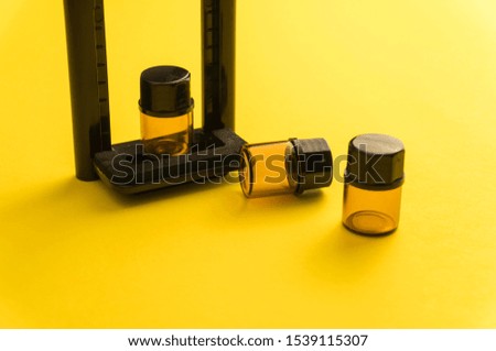 Composition of bottles for aroma, essential oil or medicine on a yellow background in other perspective. Soft focus in the middle.

