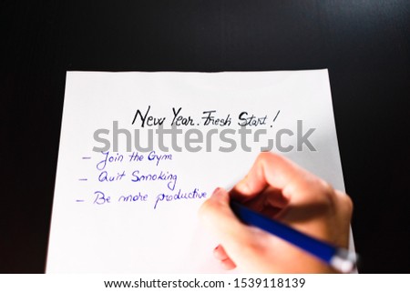 Writing New Year`s Resolutions. Christmas Resolutions. Text New Year`s Resolutions on paper. New Year, New Start text.