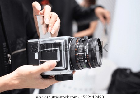 The photographer holding the camera in hand at the studio.